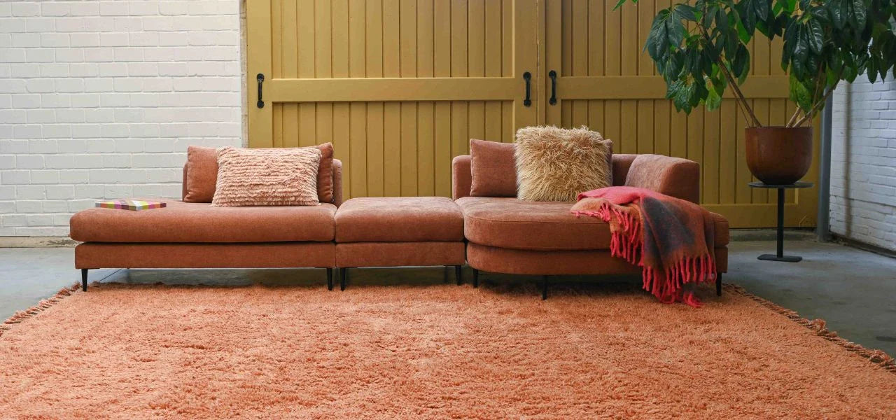 modulaire hoekbank op poten met een chaise longue met ronding in terra roest uni stof 